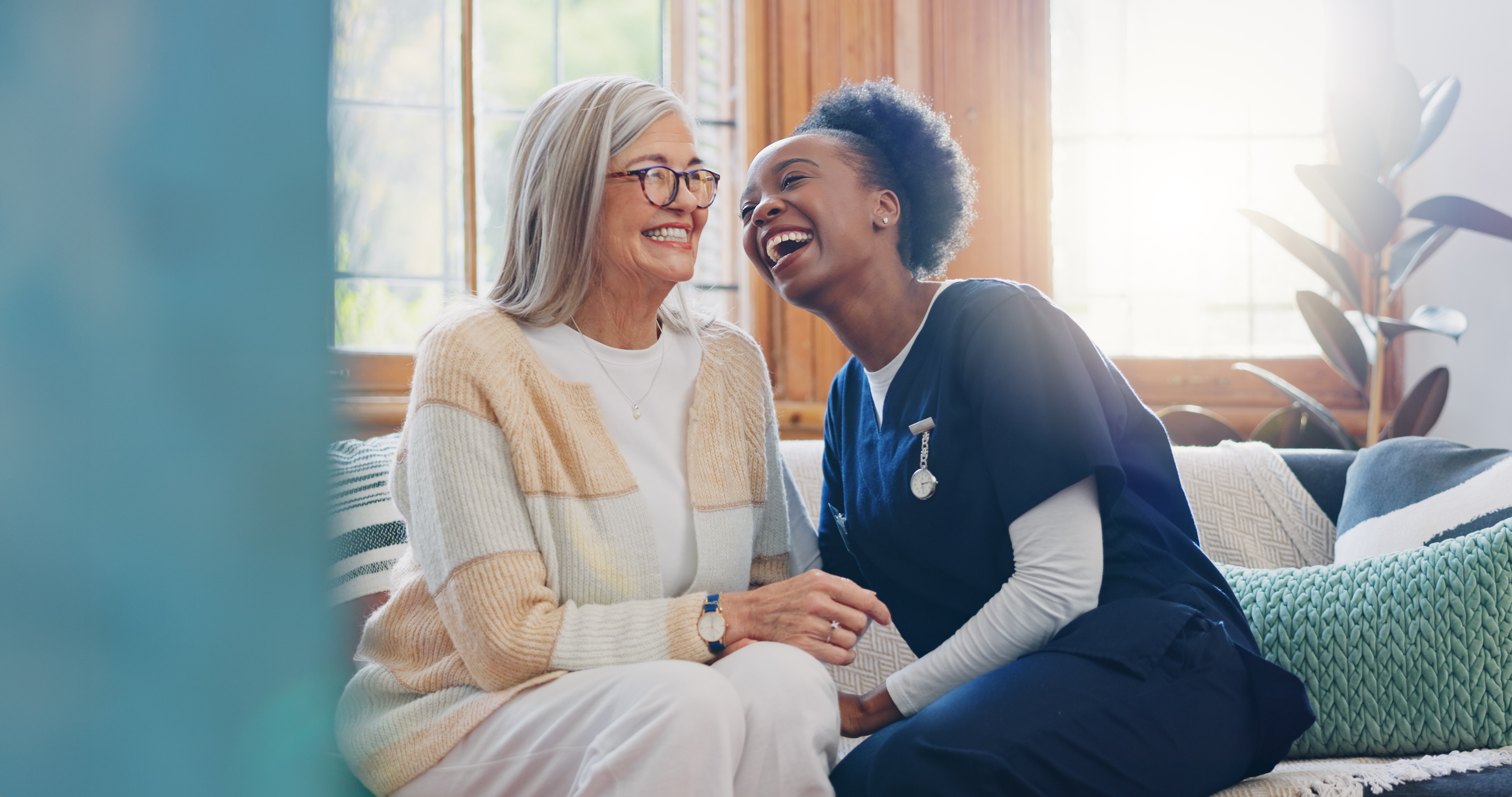 Caregiver and senior woman laughing together